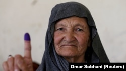 An Afghan woman shows proof of her vote after casting a ballot in Kabul on September 28.