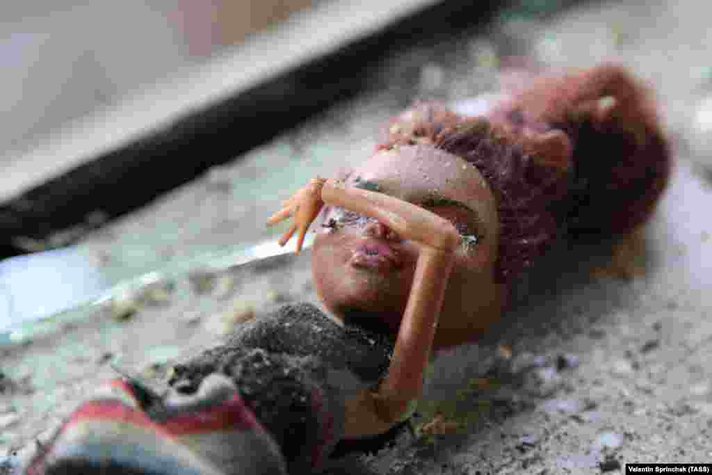 A doll is seen on a windowsill in a damaged house in Aleksandrovka in eastern Ukraine&#39;s Donetsk region following shelling. Three girls -- aged between 7 and 10 -- were reportedly injured in the attack. The village of Aleksandrovka is controlled by Russia-backed separatists. (TASS/Valentin Sprinchak)