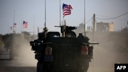 In this file photo taken on March 05, 2017 A convoy of US forces armored vehicles drives on the western outskirts of the northern Syrian city of Manbij. - The U.S. is preparing to withdraw its troops from Syria.