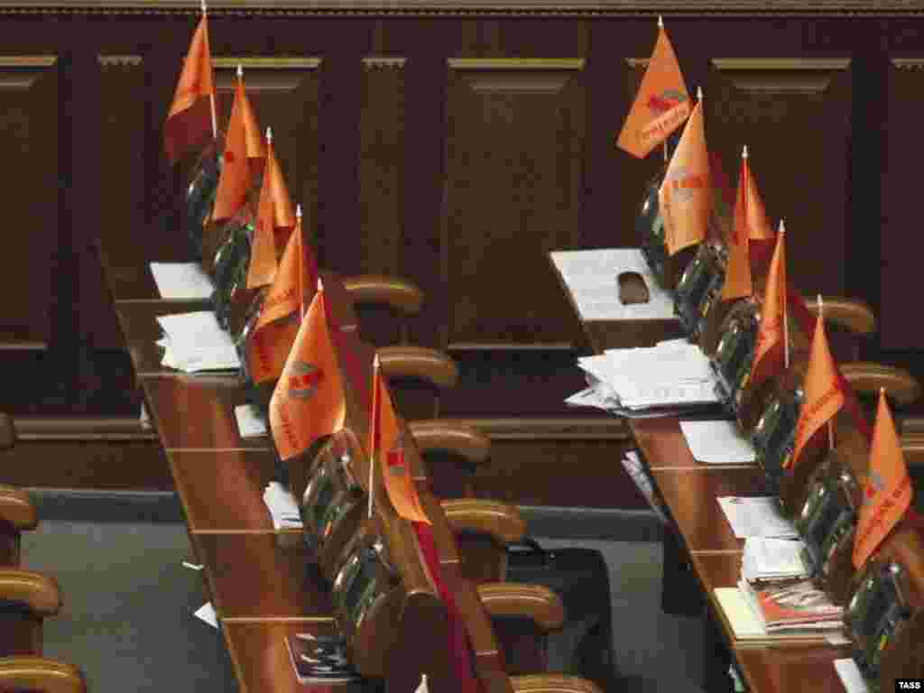 Caption: ITAR-TASS 61: KIEV, UKRAINE. APRIL 3. Orange flags over Empty seats of Our Ukraine Party members, who walked out of the Ukrainian Parliament in protest during a special plenary session