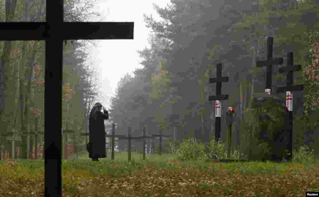 A woman prays in front of crosses at a mass grave in Kuropaty on the outskirts of Minsk on October 27. More than 100 Belarusians, including 22 writers and poets were executed by the NKVD secret service, predecessor of the present-day Belarusian KGB, overnight on October 29, 1937. October 29 is marked as an unofficial day of commemoration for victims of political repression. Between 600,000 and 1.5 million people fell victim to Stalin's repressions in Belarus, according to various estimates. (Reuters/Vasily Fedesenko)