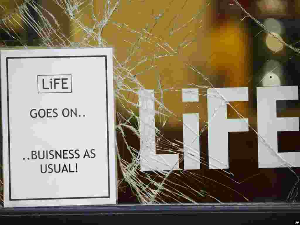 A sign is seen outside a looted shop after a night of rioting in and around Manchester, England, on August 10. Hundreds of youths rampaged through the city center, hurling bottles and stones at police and vandalizing stores. Photo by Jon Super for AP