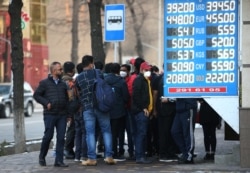Люди стоят в очереди возле обменного пункта в Алматы, 9 марта 2020 года.