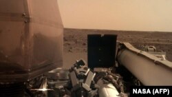 26 ноября 2018 аппарат NASA InSight передал с поверхности Марса этот снимок. Видны части зонда и поверхность планеты