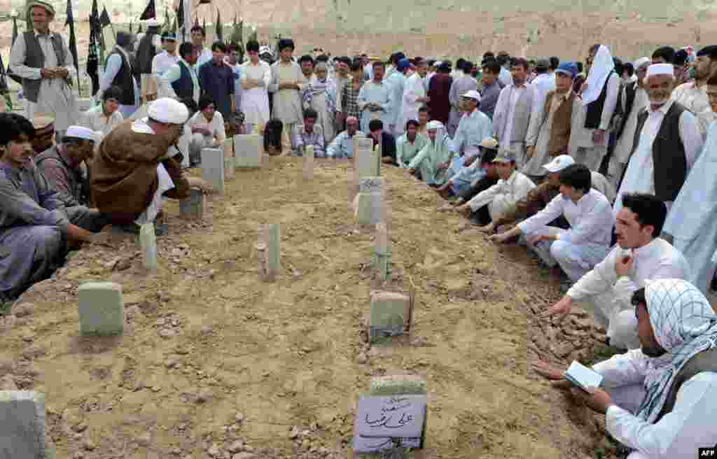 Pakistani Shi&#39;ite Muslim mourners gather around the graves of victims of a suicide bombing at a graveyard in Quetta. (AFP/Banaras Khan)