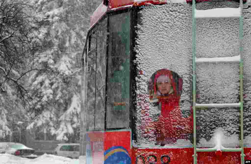 A commuter looks through a window of a tram in snowy Minsk. (AFP/Viktor Drachev)