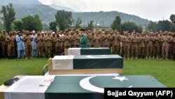 FILE: Pakistani army officials and soldiers pray beside coffins holding the bodies of three colleagues killed in cross border shelling during a funeral in Muzaffarabad, capital of the Pakistan-administered Kashmir in August.