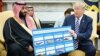 U.S. President Donald Trump (right) holds a defense sales chart with Saudi Arabia's Crown Prince Mohammed bin Salman in the White House on March 20. 