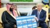 U.S. -- U.S. President Donald Trump (R) holds a defence sales chart with Saudi Arabia's Crown Prince Mohammed bin Salman in the Oval Office of the White House in Washington, March 20, 2018