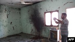 A man takes pictures in a room where a suicide blew himself up in Karachi on September 20.