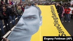 Участники митинга протеста российской оппозиции держат портрет Олега Сенцова. Москва, 10 июня