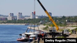 Rescuers work at the site where a barge and a crowded catamaran collided in Russia's Volga River near Volgograd on June 12.