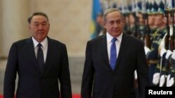 Kazakh President Nursultan Nazarbaev (left) and Israeli Prime Minister Benjamin Netanyahu review a guard of honor during a welcoming ceremony for the latter in Astana on December 14.