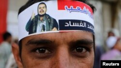 یک حوثی یمنی با سربندی که عکس عبدالمالک الحوثی رهبر شورشیان حوثی بر آن است 