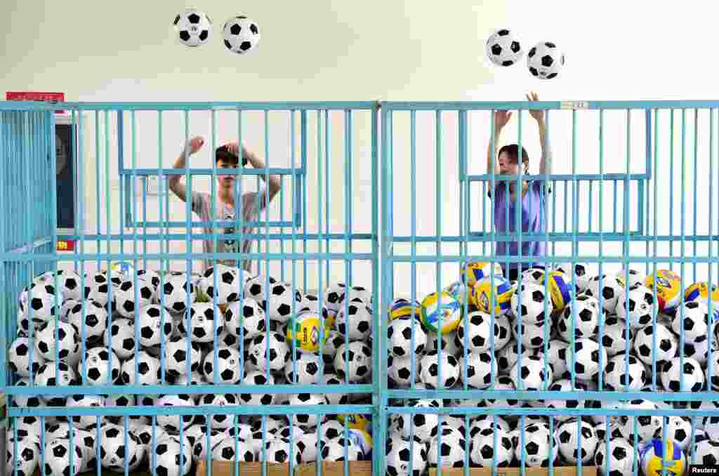 Employees sort footballs at a company manufacturing sports equipment in Yiwu, Zhejiang Province, China. (Reuters/Stringer)
