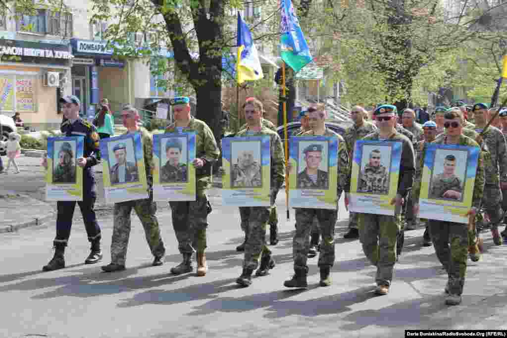 Побратими тримають у руках портрети полеглих під час бойових дій на Донбасі