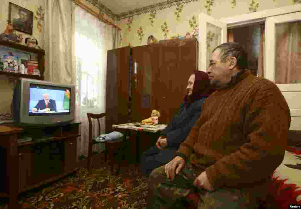 Local residents watch a live broadcast of a news conference by Belarusian President Alyaksandr Lukashenka at their house in the village of Khrapkov. Lukashenka lashed out at Russia, accusing his powerful neighbor of violating treaties and using its role as an energy supplier to &quot;grab us by the throat.&quot; &nbsp;(Reuters/Vasily Fedosenko)