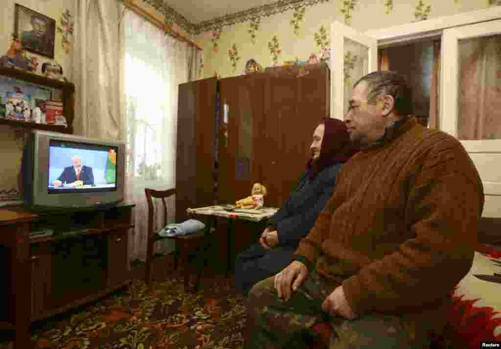 Local residents watch a live broadcast of a news conference by Belarusian President Alyaksandr Lukashenka at their house in the village of Khrapkov. Lukashenka lashed out at Russia, accusing his powerful neighbor of violating treaties and using its role as an energy supplier to "grab us by the throat." (Reuters/Vasily Fedosenko)