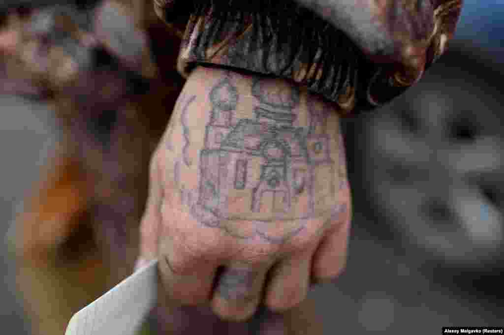 A man with an Orthodox church tattooed on his hand attends a charity event organized by Caritas.