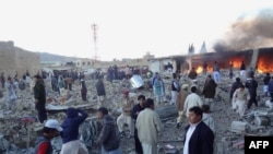 People gather after a bomb targeting Shi'ite Muslims exploded in busy market in Hazara town, an area dominated by Shi'a on the outskirts of Quetta in southwestern Pakistan.