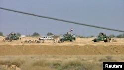 Iraqi security forces are seen outside Camp Ashraf after deadly fighting with residents in April 2011.