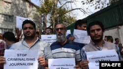 FILE: Kashmiri journalists hold placards during a protest against the communication blackout at Press Club Kashmir in Srinagar, the summer capital of Indian administered Kashmir in October 2019.