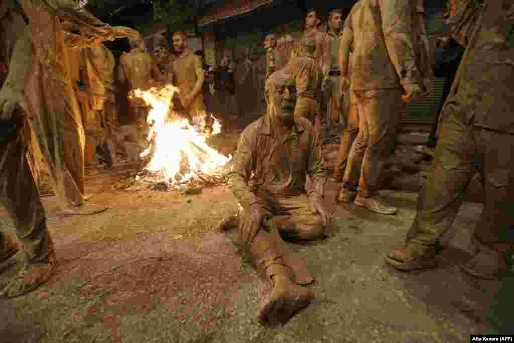 Iranian Shi&#39;ite Muslims sit after rubbing mud on their bodies during the Kharrah Mali ritual to mark the Ashura religious ceremony, in the city of Khorramabad, some 470 kilometers southwest of Tehran, on October 1. The ritual commemorates the seventh-century slaying of the Prophet Muhammad&#39;s grandson, Imam Hussein. (AFP/Atta Kenare)