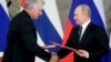 Russian President Vladimir Putin (right) and Cuban President Miguel Diaz-Canel exchange documents following their meeting at the Kremlin in Moscow on November 2. 