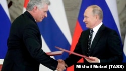 Russian President Vladimir Putin (right) and Cuban President Miguel Diaz-Canel exchange documents following their meeting at the Kremlin in Moscow on November 2. 