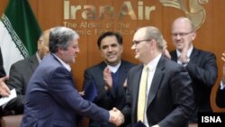 Iran Air компаниясының басшысы Фархад Парвареш (сол жақта) Boeing компаниясының басшылығымен жолаушылар ұшағын сатып алу туралы келісім жасасу кезінде. Тегеран, 11 желтоқсан 2016 жыл.
