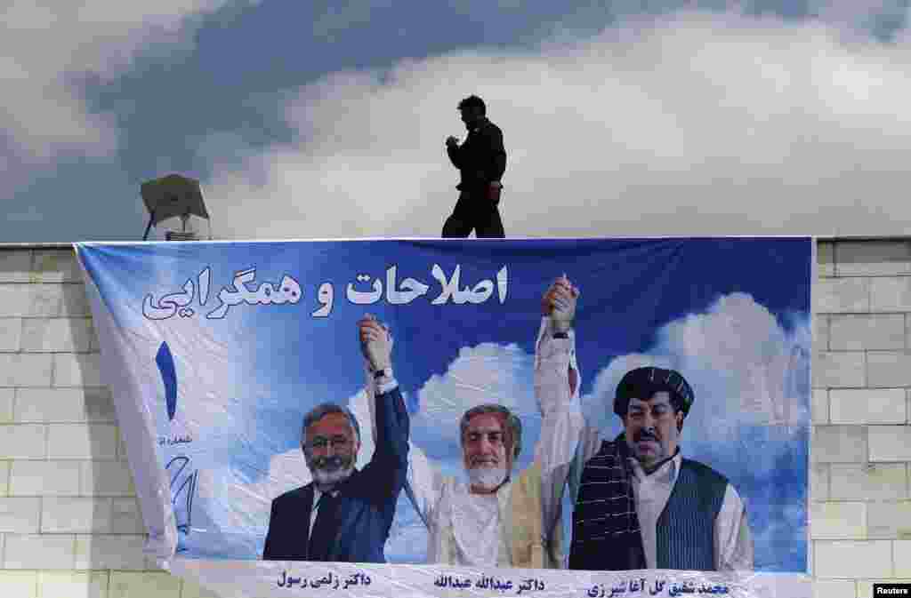 A man installs a banner for Afghan presidential candidate Abdullah Abdullah during the first day of the second round of the presidential election campaign in Kabul on May 22. (Reuters/Omar Sobhani)