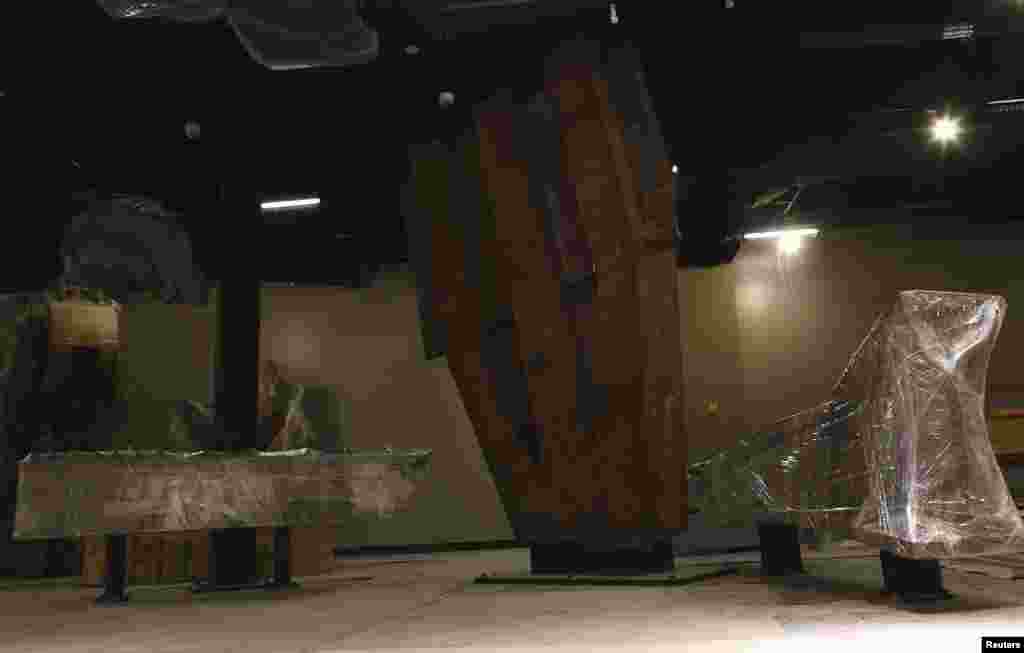 The "Cross" (left), intersecting steel beams found in the rubble of 6 World Trade Center, and a fragment of a trident column that formed the exterior structure of the World Trade Center buildings