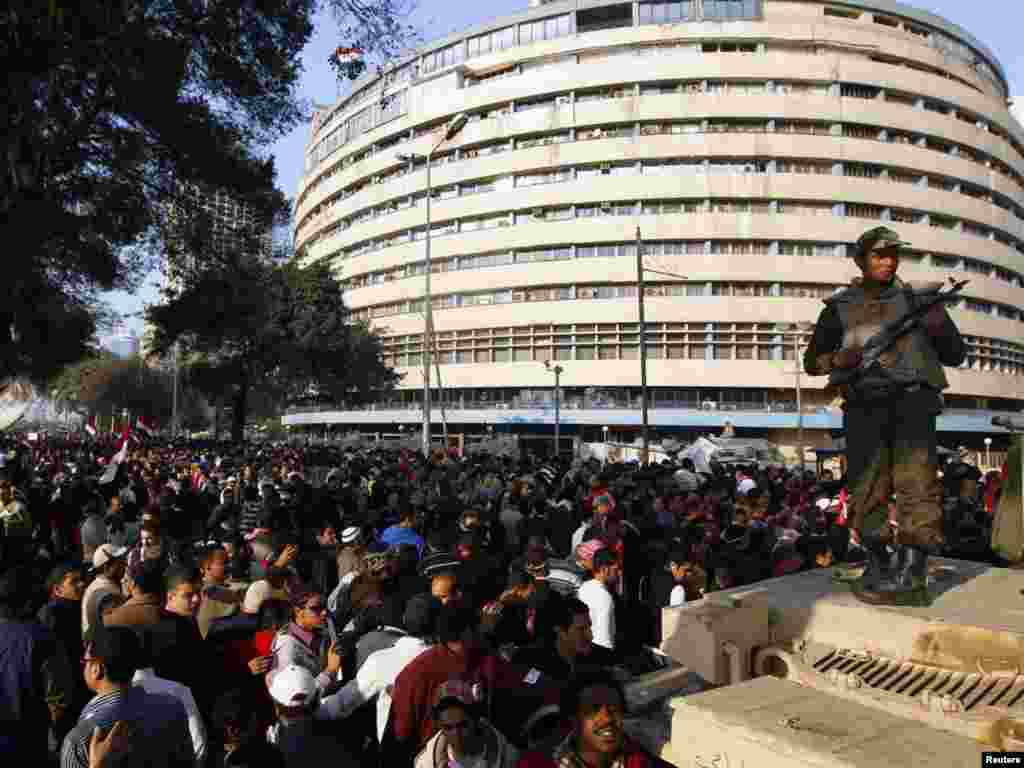 Vojnik i demonstranti ispred zgrade nacionalne TV u Kairu.