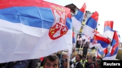 People wave Serbian flags during a rally in the ethnically divided town of Mitrovica, where local Serbs refuse to accept the independence declared by Kosovo's Albanian majority.