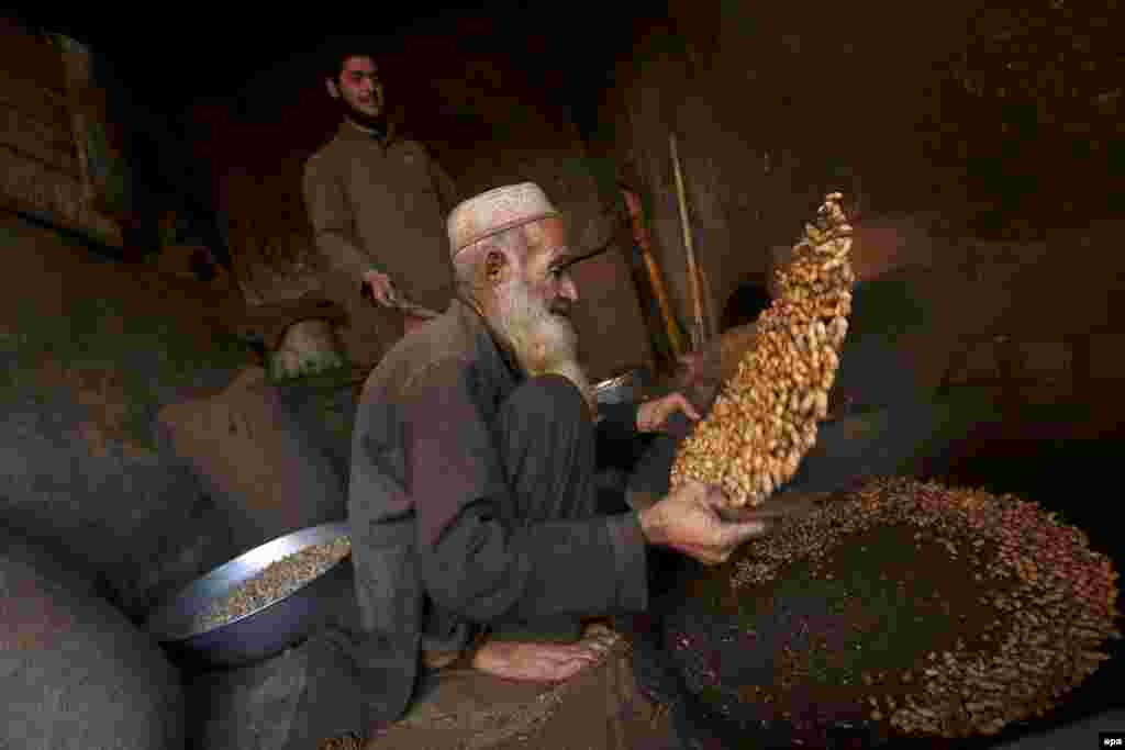 A vendor prepares peanuts on a roadside in Peshawar, Pakistan. (epa/Arshad Arbab)