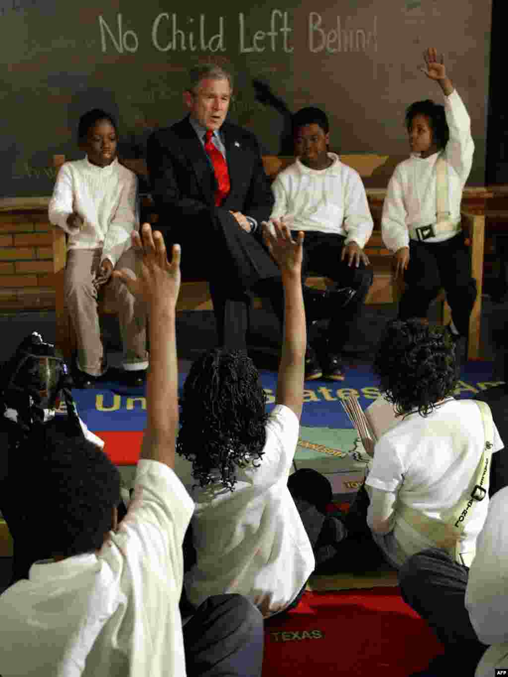 'No Child Left Behind' education law - U.S. President George W. Bush sits with students Khadijah McCainn (left), Damien Goolsby (center), and Darlet Horton (right) as he talks to students on the anniversary of the "No Child Left Behind Act" on January 5, 2004, at Pierre Laclede Elementary School in St. Louis, Missouri.