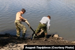 Активисты "Сути времени" вытаскивают фрагмент памятника Сталину на берег