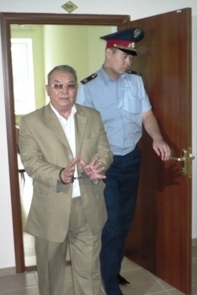 Полицейский выводит бывшего советника акима Западно-Казахстанской области Алпамыса Бектурганова в наручниках из зала суда в день объявления приговора. Уральск, 13 августа 2009 года