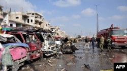 Damaged vehicles line the site of a double car-bomb attack in the Al-Zahraa neighborhood of the central Syrian city of Homs on February 21. More than 140 people killed in bombings in Damascus and Homs.