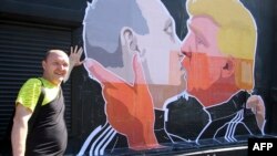 A Lithuanian restaurant owner stands next his establishment's mural depicting U.S. President-elect Donald Trump and Russian President Vladimir Putin greeting each other with a kiss (file photo). 