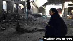 Жительница села Сортобе Жамбылской области во дворе своего дома, сожженного во время межэтнических столкновений в ночь на 8 февраля.