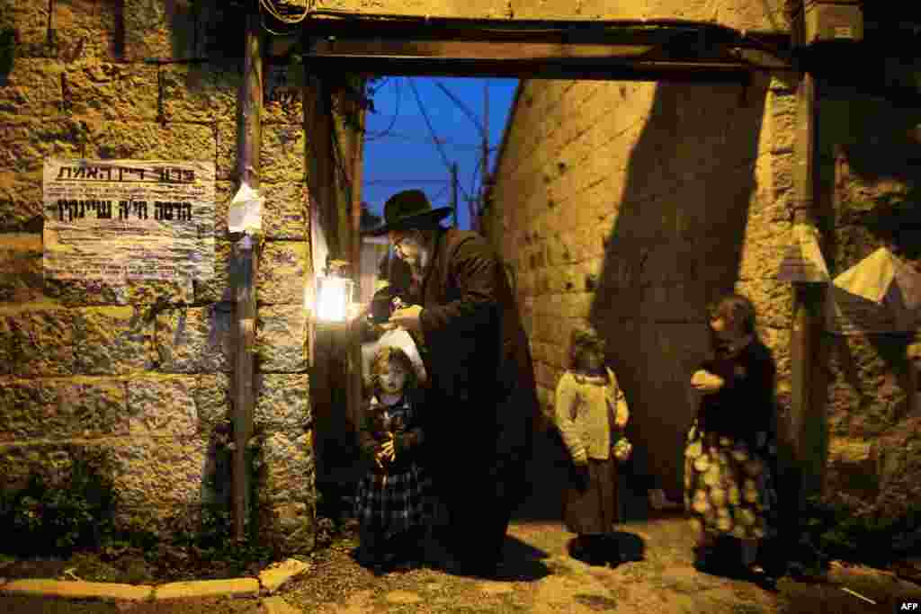 An ultra-Orthodox Jewish man lights candles on the eighth and final night of the Jewish holiday of Hanukkah in Jerusalem. (AFP/Menahem Kahana)