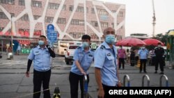 Policija postavlja ogradu pred tržnicom Xinfadi, Peking, 12. lipnja