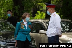 Женщина и сотрудник полиции у входа в Парк имени 28 гвардейцев-панфиловцев. Алматы, 9 мая 2020 года.
