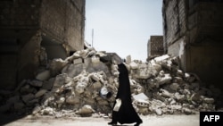 Syria -- A Syrian woman walks past a destroyed building while reaching a food distribution centre in Aleppo on 13Sep2012