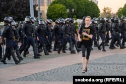 Дзяўчына ў майцы зь «Евай» уцякае ад амапаўцаў, 9 жніўня