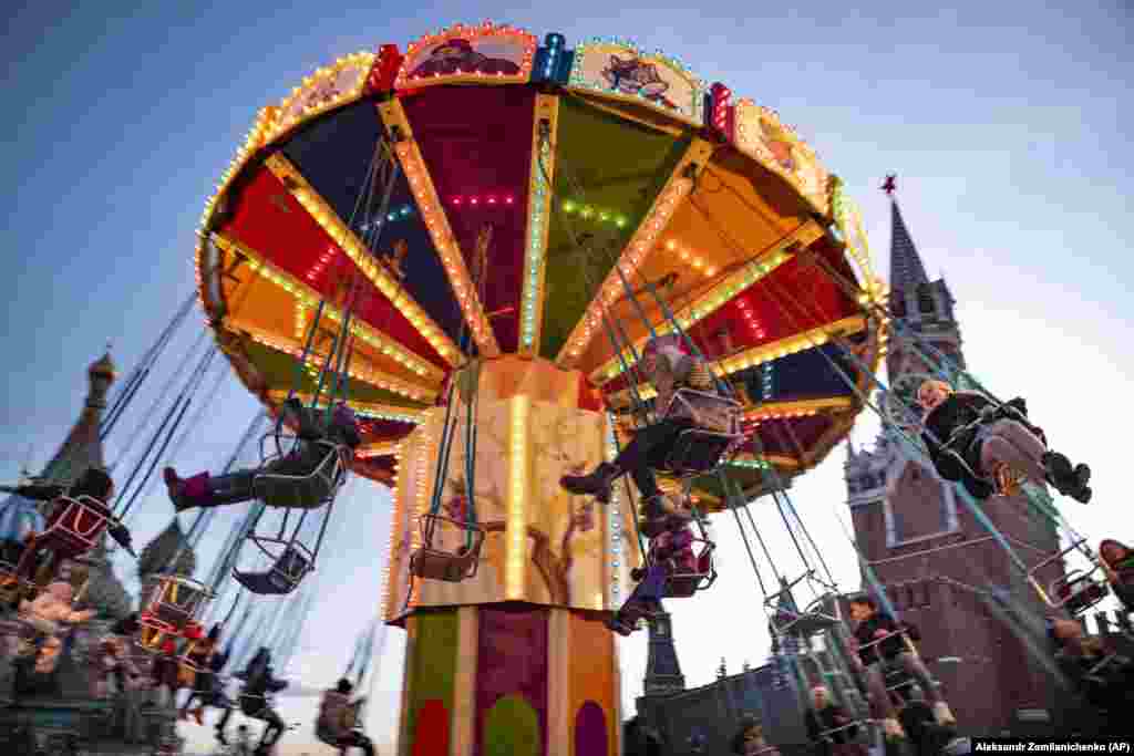 People ride a carousel on Moscow&#39;s Red Square, which has been festooned with seasonal decorations. (AP/Alexander Zemlianchenko)