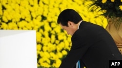 Japanese Prime Minister Naoto Kan places flowers at the alter during a memorial ceremony for the national war dead in Tokyo today.