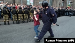 Поліцейський затримує дівчину-підлітка під час акції протесту в російському Петербурзі, 9 вересня 2018 року