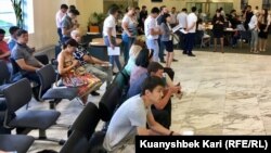 Банкте кезек күтіп тұрған халық. Көрнекі сурет.